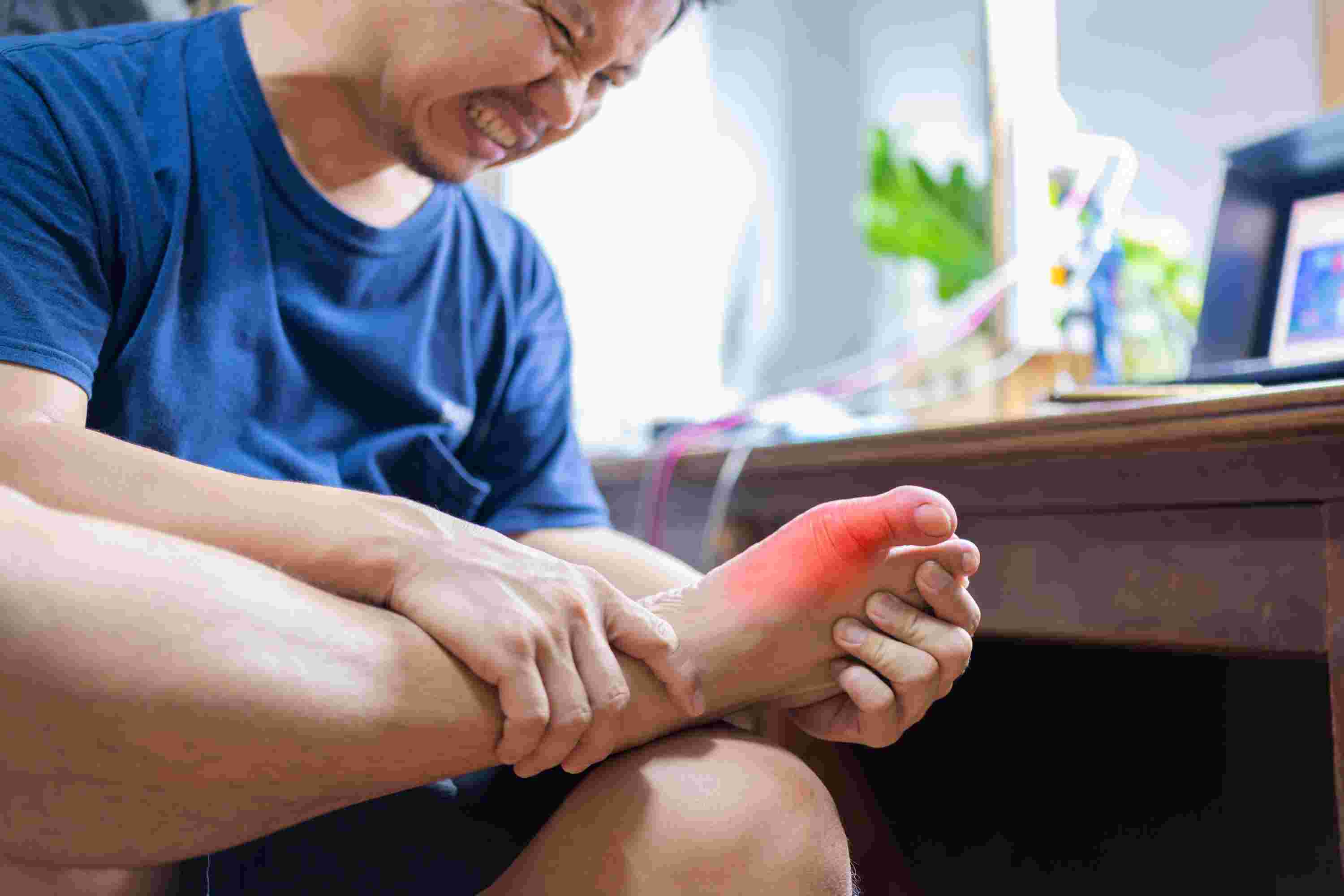 man-with-painful-inflamed-gout-his-foot-around-big-toe-area(1).jpg