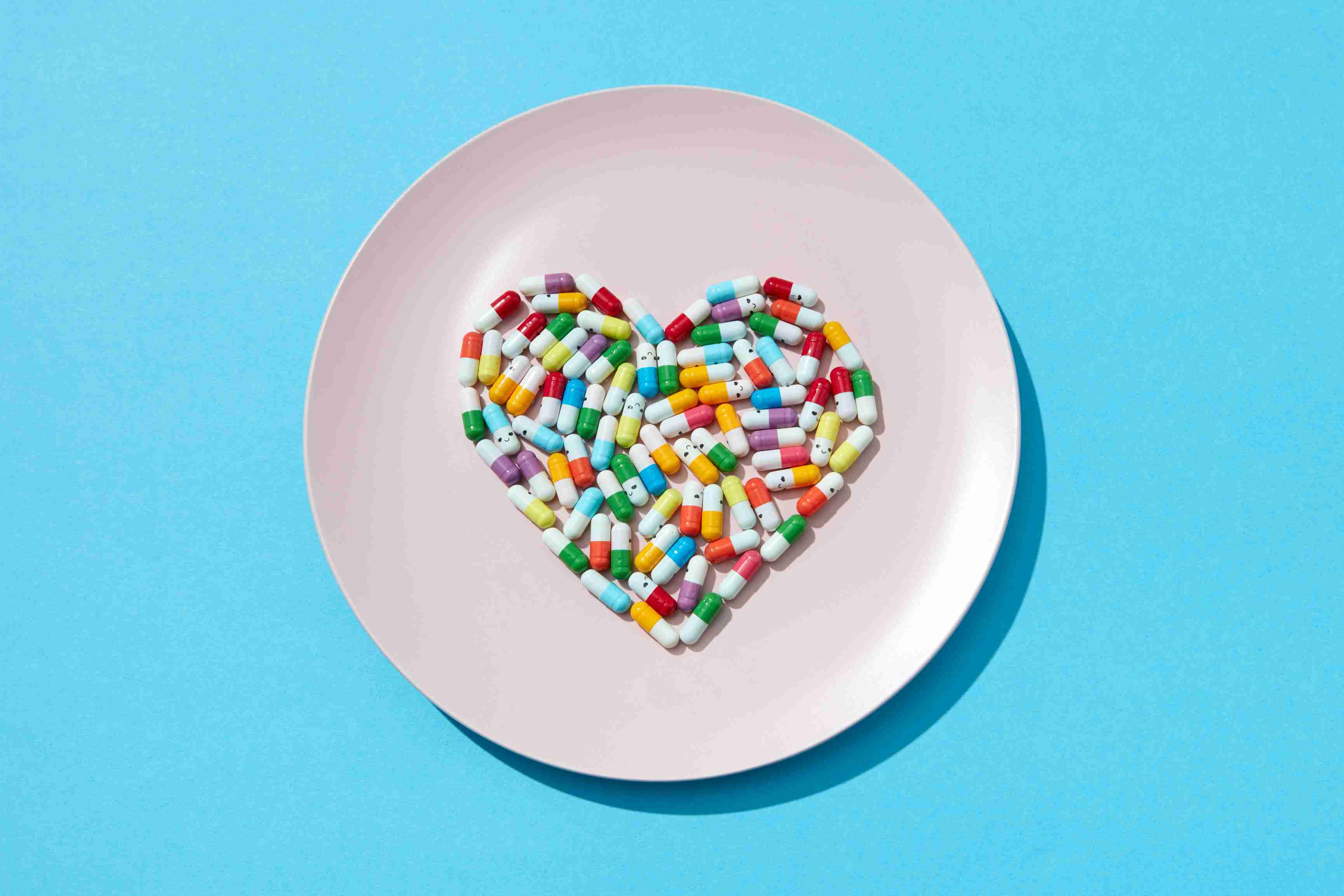 many-different-pills-supplements-shape-heart-white-plate-blue-wall-cardiovascular-disease-prevention-flat-lay.jpg